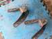 1996 Ford Bronco - These are two rusty metal brackets, likely suspension or mounting components, resting on a blue mat.