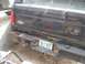 1996 Ford Bronco - Tools are laid out on the rusty rear bumper of a black Ford truck, ready for repairs.