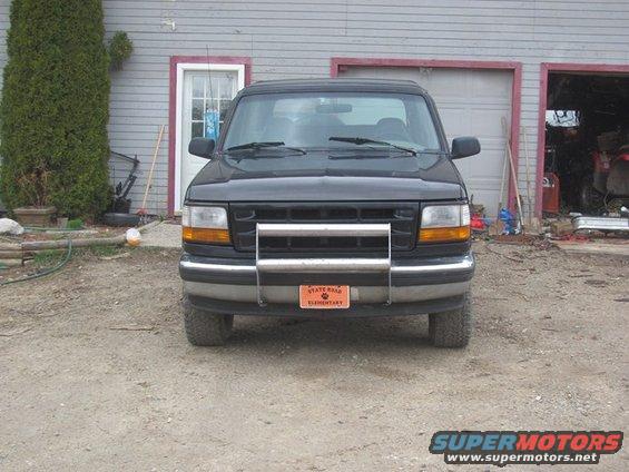 Front view of a dark-colored Ford F-150 pickup truck with a chrome bull bar. License plate reads 'STATE ROAD ELEMENTARY'