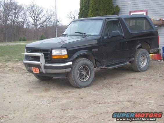 Black 1996 Ford Bronco parked on dirt, front bumper guard, side step, visible 'Bronco' badge