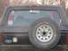 1996 Ford Bronco - Rear view of a black Ford Bronco with a spare tire and decals on the window.