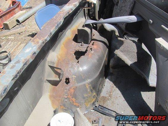 Rusted interior wheel well and frame with visible Supermotors.net logo
