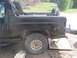1996 Ford Bronco - This black Ford Bronco is shown from the side, with its rear quarter panel and spare tire visible.
