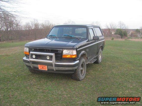 Black 1996 Ford Bronco with a brush guard and aftermarket wheels parked on grass