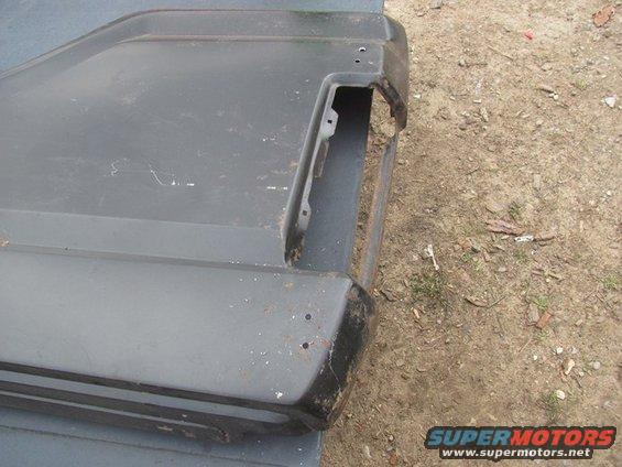 Dark gray rear bumper corner with cut-out for taillight