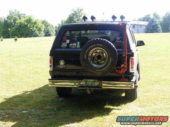Black Ford Bronco, rear view, with spare tire on back and a Hi-Lift jack mounted to it