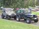 1988 Ford Bronco - A tan Jeep Wrangler is parked next to a black Jeep Wrangler, both facing forward.