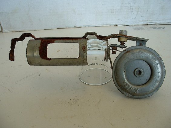 Rusted metal assembly with glass cylinder and Delco horn