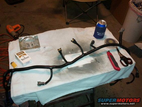 wiring harness on a table with cigarettes, lighter, ashtray, utility knife, and scissors