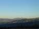 1988 Ford Bronco - A vast mountain range stretches across the horizon under a bright, cloudless sky.