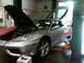 1990 Ford Bronco - A silver Ferrari 360 Modena is shown with its hood and doors open while elevated on a service lift.