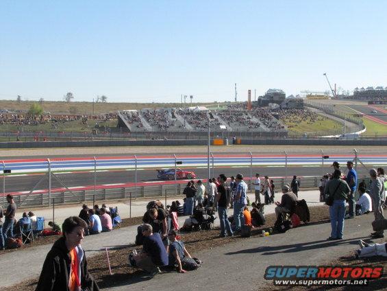 Red race car on track with spectators in the background