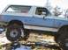 1988 Ford Bronco - This 1988 Ford Bronco is equipped for off-road use, navigating a challenging terrain with snow and rocks.