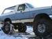 1988 Ford Bronco - This lifted Ford Bronco is shown off-road in a snowy environment, with its large tires covered in mud.