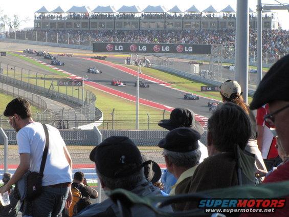 Race cars on a track with spectators in the stands and LG billboards
