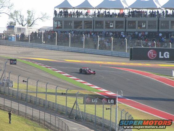 Race car on a track with spectators in the background and LG branding