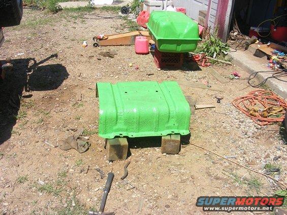 two green fuel tanks, one on the ground on blocks, another on a milk crate