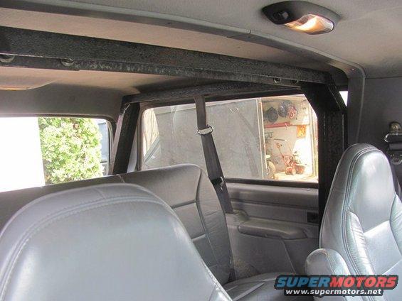 Interior view of vehicle with gray leather seats and roll cage. Supermotors.net logo visible