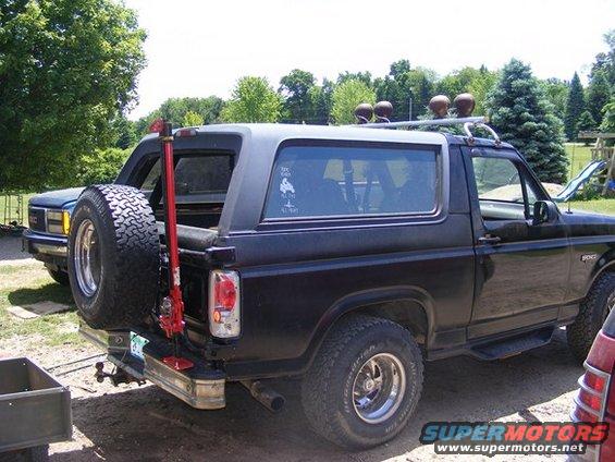 1996 Ford Bronco rear view with spare tire carrier, jack, and another vehicle behind it
