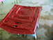 1970 Ford Mustang - Underside of a red car hood, likely undergoing restoration or painting, is propped up on stands.