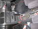 1993 Mazda MX-3 - The interior of a car features a custom shifter and pedals, with visible wiring under the center console.