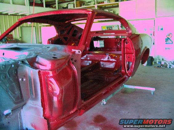 1970 Ford Mustang body shell on a stand, undergoing restoration in a workshop