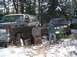 1988 Ford Bronco - Two muddy SUVs, including a 1988 Ford Bronco, sit in a snowy, wooded area after off-roading.