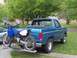 1985 Ford Bronco - A blue 1985 Ford Bronco is shown with a dirt bike mounted on a carrier attached to the trailer hitch.