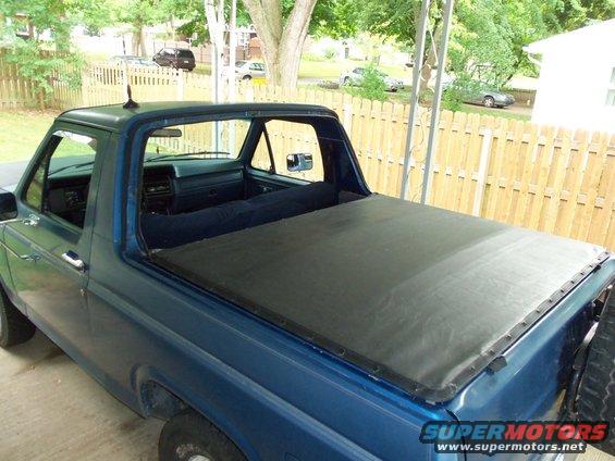 Blue pickup truck with a black tonneau cover, seen from the 3/4 front angle