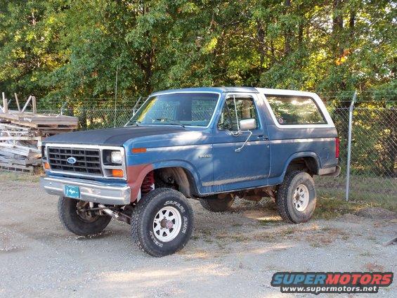 Blue Ford Bronco with aftermarket wheels and lift kit parked outside