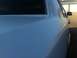 1997 Lincoln Town Car - Close-up view of the rear quarter panel and window trim of a light blue sedan.