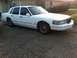 1997 Lincoln Town Car - White 1997 Lincoln Town Car with chrome trim details parked outside a brick house.