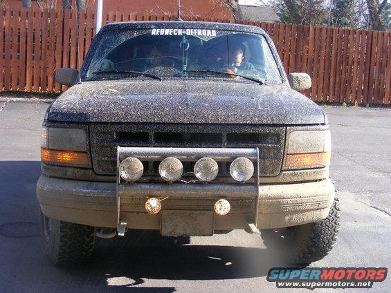Mud-covered 1996 Ford Bronco front view with brush guard and four driving lights