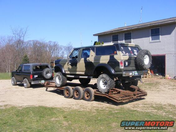 1996 Ford Bronco on trailer, another black Bronco parked nearby