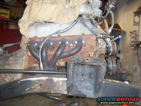 Engine block with exhaust headers and part of a vehicle frame