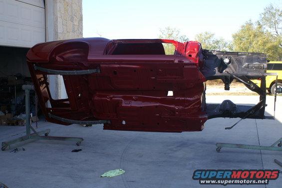 Red 1970 Ford Mustang body shell on rotisserie