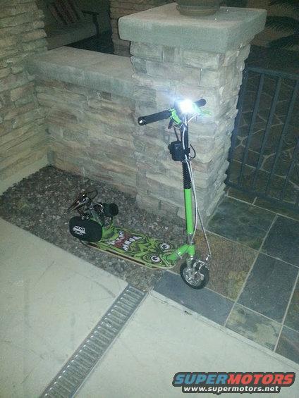 Green motorized scooter with cartoon graphics and headlights
