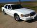 1997 Lincoln Town Car - A white sedan with chrome accents is parked outdoors under a clear blue sky.