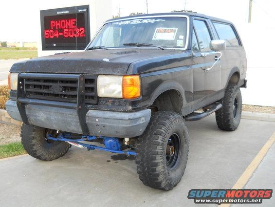 1992 Ford Bronco lifted with large tires and aftermarket grille guard