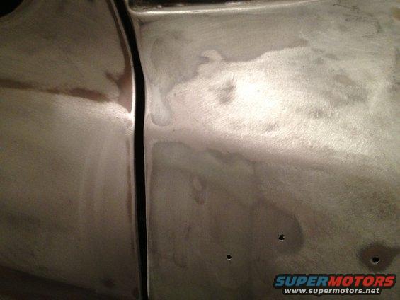 Close-up of a vehicle door seam with body filler and primer