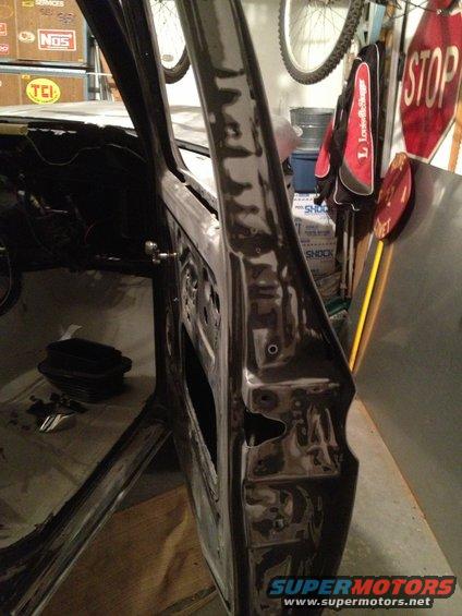 Open car door frame, showing interior structure and some tools on the floor