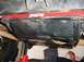 1995 Jeep Wrangler - Vehicle underbody with skid plate and Skyjacker brace, being worked on with a jack.