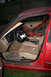 1996 BMW 3 Series - The interior of a red BMW shows damage to the driver's seat and the passenger side door panel is removed.