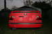 1996 BMW 3 Series - Rear view of a red 1996 BMW 328i with a spoiler and dual exhaust pipes.
