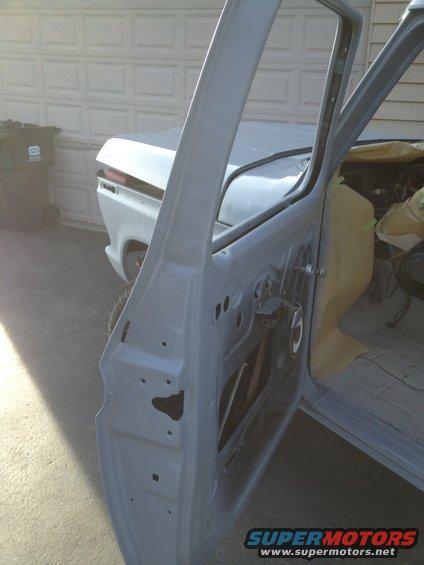 Open truck door showing interior, primer gray paint, and dashboard area
