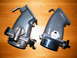2004 Ford Crown Victoria - Two throttle bodies are shown side-by-side on a wooden surface.