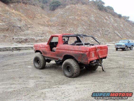 red SUV with roll cage and big tires, another blue SUV in background