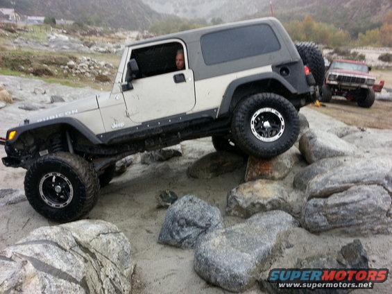 Jeep Wrangler Rubicon navigating rocks, another Jeep visible in background