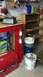 2004 Aston Martin Virage - Garage workbench setup with various tools, storage containers, and a battery charger.