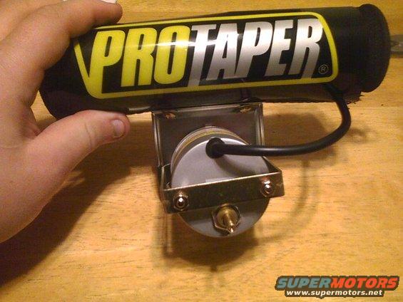 ProTaper handlebar pad over a carburetor, held by a hand